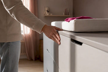 Anoniem meubel met aankleedkussen in de babykamer