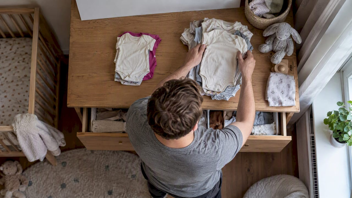 Vader sorteert babyrompertjes op twee maten